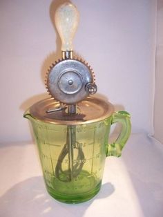 a green blender sitting on top of a white counter next to a bottle opener