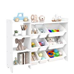 a white book shelf filled with lots of books next to a toy elephant and other toys