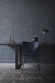 a chair and table in front of a brick wall