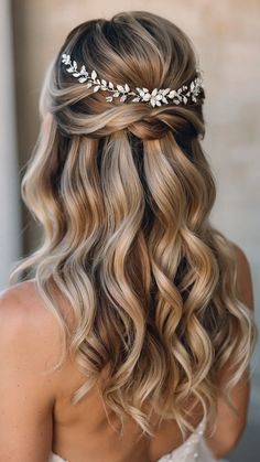 a woman with long blonde hair wearing a bridal headpiece and a flower crown