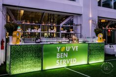 an outdoor bar is lit up with green lights and the words you've been served on it