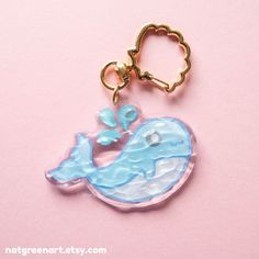 a key chain with a blue whale on it's side and a gold hook