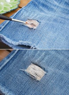 a pair of jeans that have been ripped and are sitting on a table with a paintbrush in it