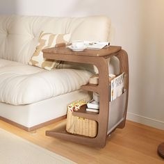 a white couch sitting next to a wooden table on top of a hard wood floor