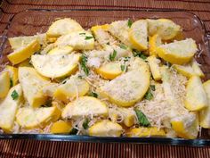 a glass casserole dish filled with potatoes and parmesan cheese on top