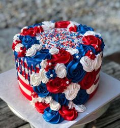 a red, white and blue cake sitting on top of a wooden table