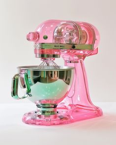 a pink mixer sitting on top of a table