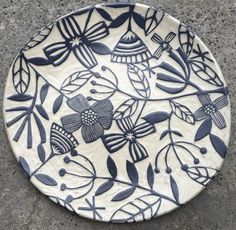 a white and blue plate sitting on the ground