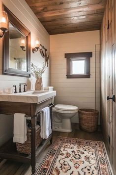 a bathroom with a sink, toilet and rug on the floor in front of it