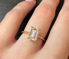 a woman's hand with a ring on it and an emerald stone in the middle