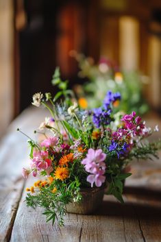 a bunch of flowers that are sitting in a vase on a wooden table with other flowers