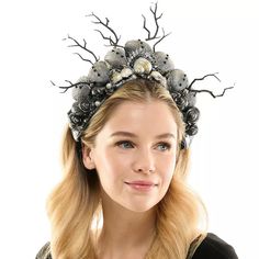 a woman wearing a headpiece with seashells on it's sides and branches