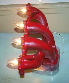 a red object sitting on top of a table next to some lights and a light bulb