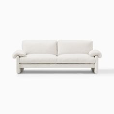 a white couch sitting on top of a white floor