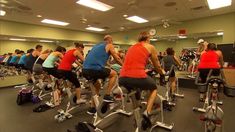 a group of people riding stationary bikes in a gym