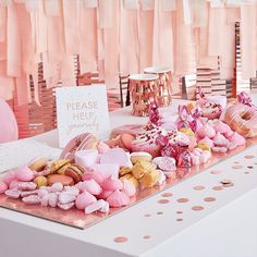 a table topped with lots of pink and gold desserts