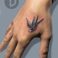 a hand with a bird tattoo on it