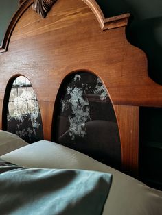 a wooden headboard with two arched windows