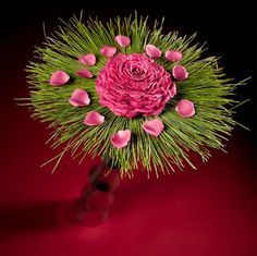 a vase filled with pink flowers on top of a red table