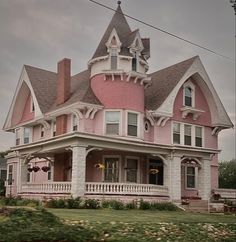 a pink victorian style house with white trim