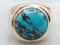 a gold ring with a turquoise stone in it