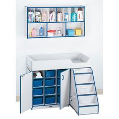 a white and blue toy room with shelves, bins and drawers on the wall