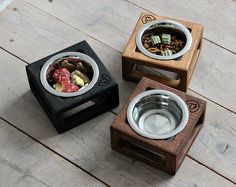 three wooden bowls with food in them sitting on the floor next to each other,