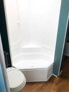 a white toilet sitting next to a walk in shower