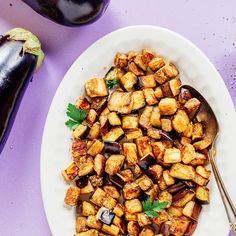 a white plate topped with fried eggplant next to an eggplant