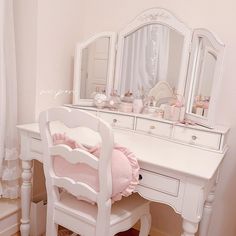 a white dressing table with a pink pillow on it