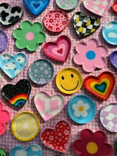 many different types of heart shaped magnets on a pink and white checkered table cloth