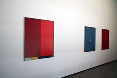 three paintings are hanging on the wall next to each other in an empty room with white walls