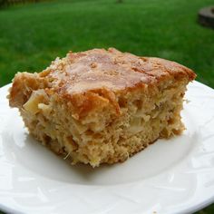 a piece of cake sitting on top of a white plate in front of some grass