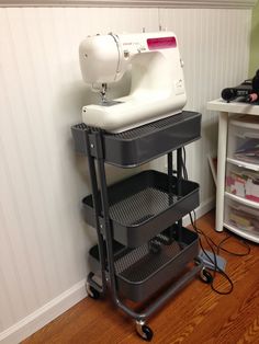 a sewing machine sitting on top of a cart next to a wall with white walls