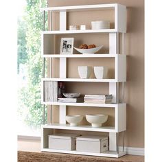 a white shelf with bowls and plates on it