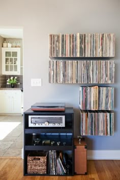 a record player is sitting on top of a shelf in front of a wall full of records