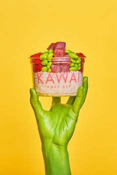 a person's hand holding up a container with food in it and the words kawa on it