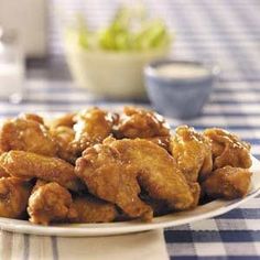 a white plate topped with fried chicken on top of a blue and white table cloth