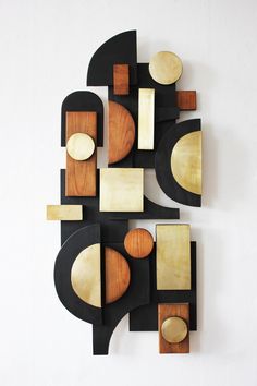 an abstract sculpture made out of wood and plywood on a white wall with no one around it