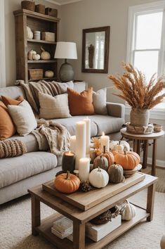 a living room filled with furniture and lots of fall decorations on top of the coffee table