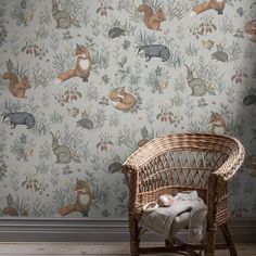 a chair in front of a wallpaper with rabbits and flowers on it, next to a wicker basket