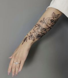 a woman's arm with a flower tattoo on the left side of her arm