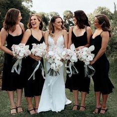 a group of women standing next to each other holding bouquets