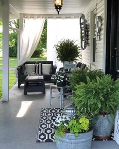 a porch with potted plants and chairs on it