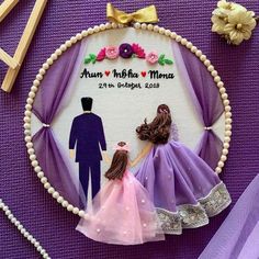 a cake topper with a couple holding hands in front of purple fabric and flowers