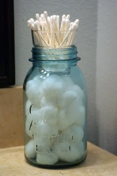 a mason jar filled with cotton floss and toothpicks