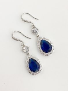 Luxury blue sapphire cubic zirconia bridal tear drop earrings in rhodium plated brass setting. Earrings feature a large teardrop with pear cut blue sapphire cubic zirconia center surrounded by tiny round zirconia crystals. Teardrop dangles from a round cubic zirconia connector and zirconia detailed ear wire. Total length of the earrings is 5 cms. For matching necklace click: https://www.etsy.com/listing/252983612/blue-sapphire-cubic-zirconia-bridal?ref=shop_home_active_13 For matching bracelet c Elegant Blue Teardrop Bridal Earrings, Blue Elegant Teardrop Pendant Earrings, Elegant Blue Pear-shaped Teardrop Earrings, Elegant Blue Teardrop Earrings, Blue Elegant Teardrop Earrings, Blue Pear-shaped Teardrop Earrings For Formal Occasions, Elegant Blue Drop Bridal Earrings, Elegant Blue Teardrop Pendant Earrings, Blue Pear-shaped Teardrop Earrings