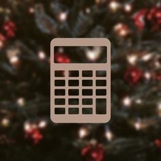 a calculator sitting in front of a christmas tree with red and green lights