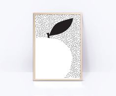 a black and white apple with a leaf sticking out of it