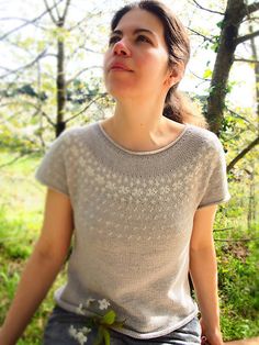 a woman standing in the woods looking up